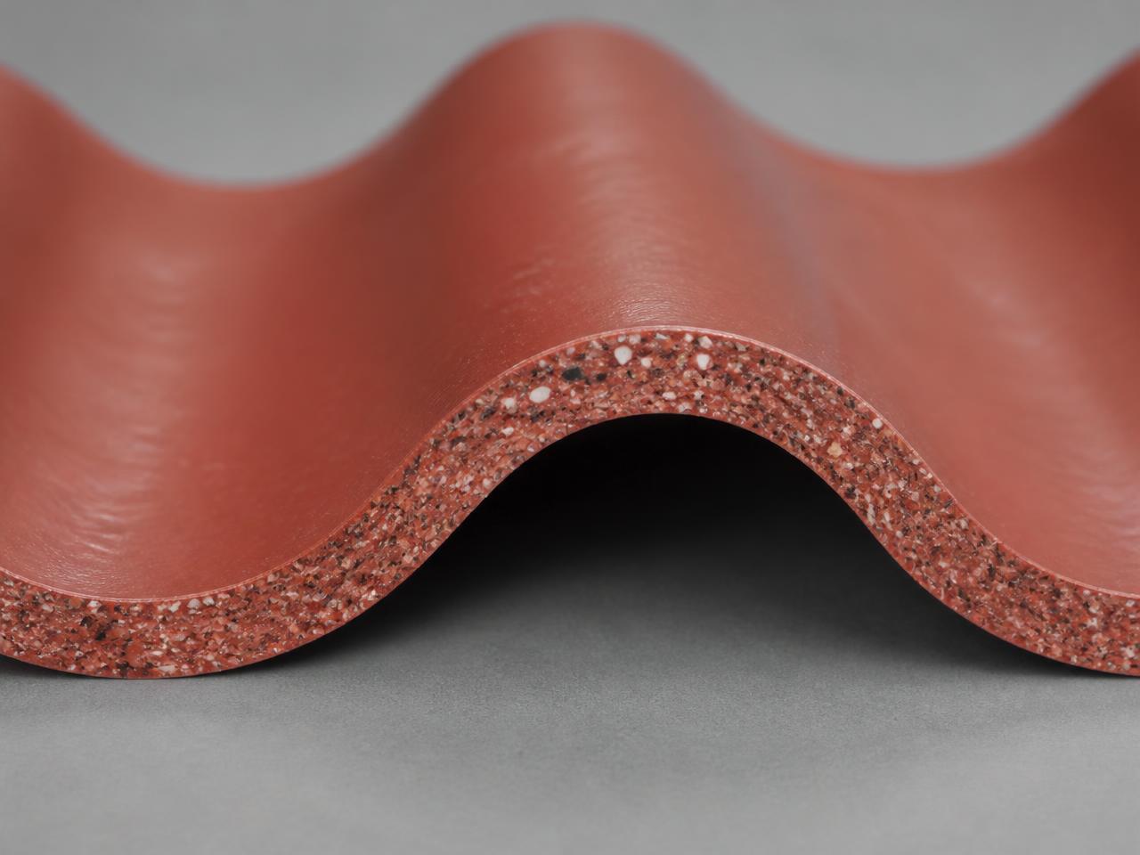 Cut edge of a Terracotta Red corrugated PolyAl sheet showing thickness and recycled composition