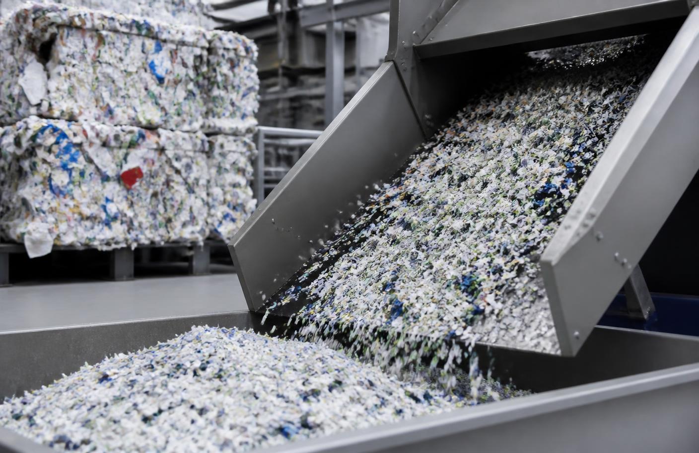PolyAl flakes recovered from recycled beverage cartons on a processing conveyor